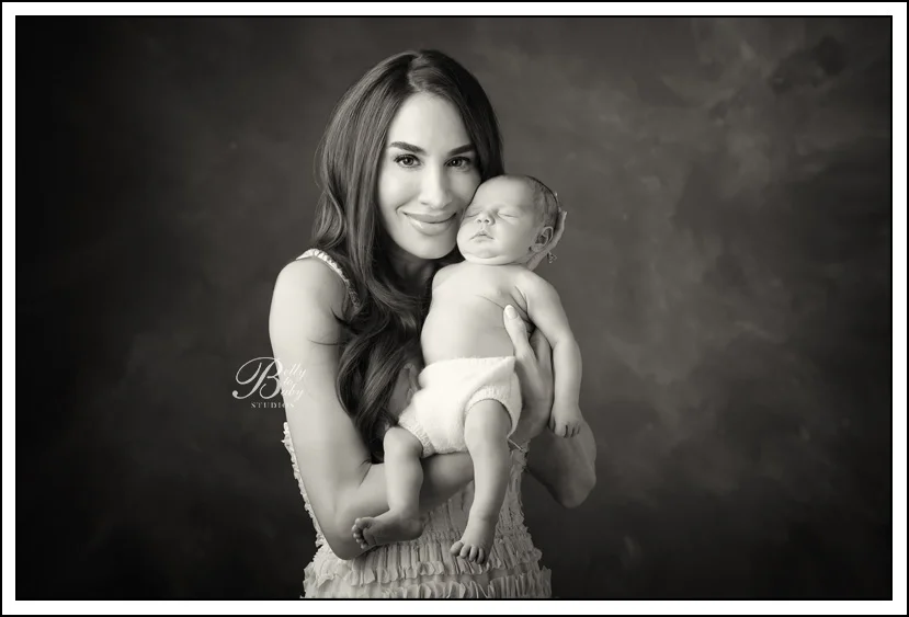 Houston Maternity Photographer Mother holding her newborn baby during a luxury newborn photography session at Belly to Baby Studios in Houston.