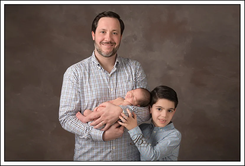 Houston Maternity Photographer Father holding newborn baby during professional Houston newborn portrait session.