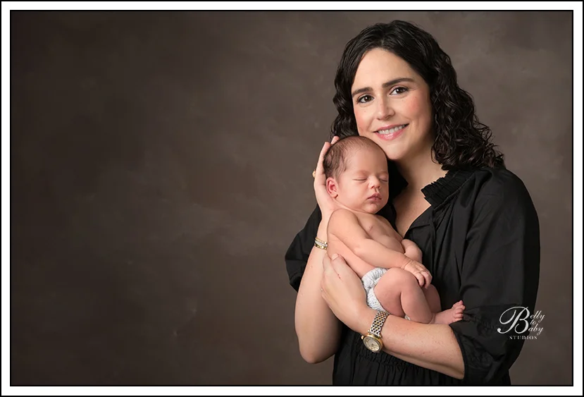 Houston Maternity Photographer New mother holding newborn baby during Houston studio newborn portrait session.