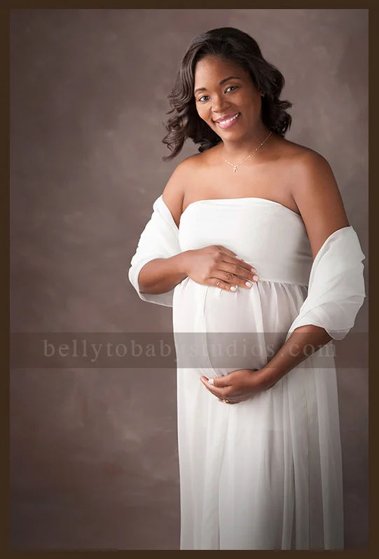 Houston Maternity Photographer Expectant mother wearing an elegant white gown for a timeless Houston maternity portrait