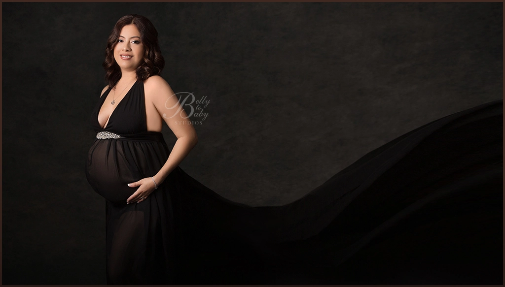 expecting mother wearing flowing maternity gown in studio expecting mother wearing flowing maternity gown in studio